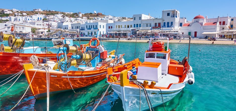 Λιμάνι-με-ξύλινα-ψαρόβαρκα-στην-πόλη-της-Χώρας-την-ηλιόλουστη-καλοκαιρινή-μέρα-στη-Μύκονο-—-Ελληνικό-τοπίο-950x450